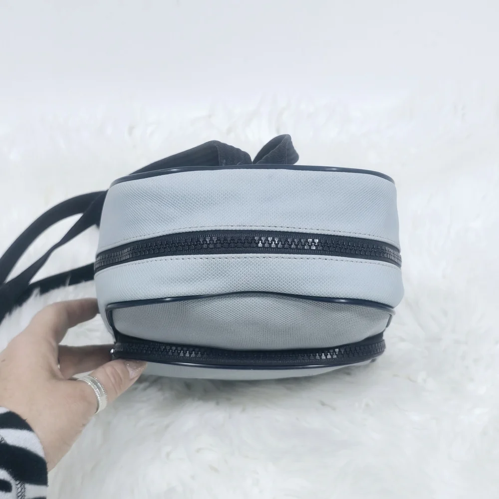 Lacoste mini backpack in a soft light blue shade with navy blue trim accents.